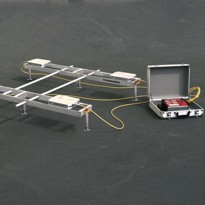 Corner weight scale setup with sensor pads, yellow cables, and control unit